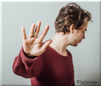 A young man in denial saying no with his hand.