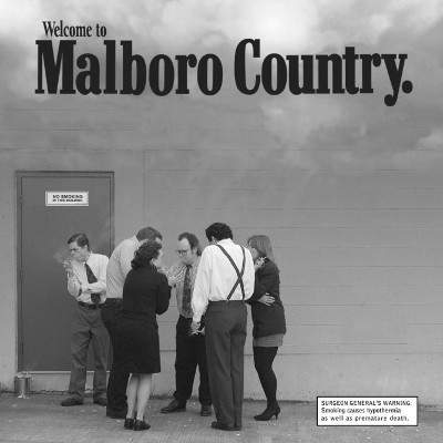 Smokers smoking behind a store while cold