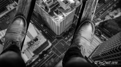 A man walking on boards between building 50 stories up