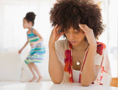 Woman fixating on wanting to smoke while her child plays in the background.