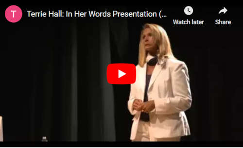 Terrie Hall standing on a stage during her 'In her own words' school presentation